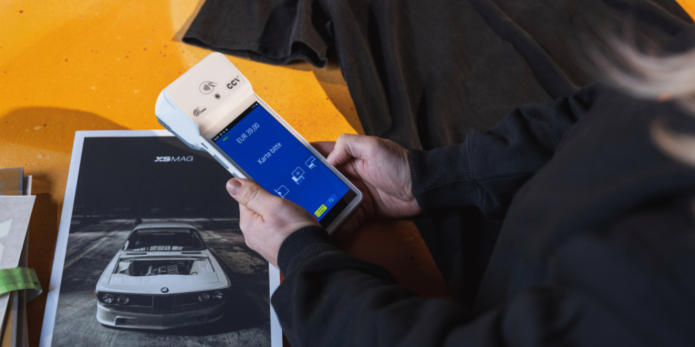 Kartenterminal CCV A960 wird über Tresen mit Automagazin gehalten